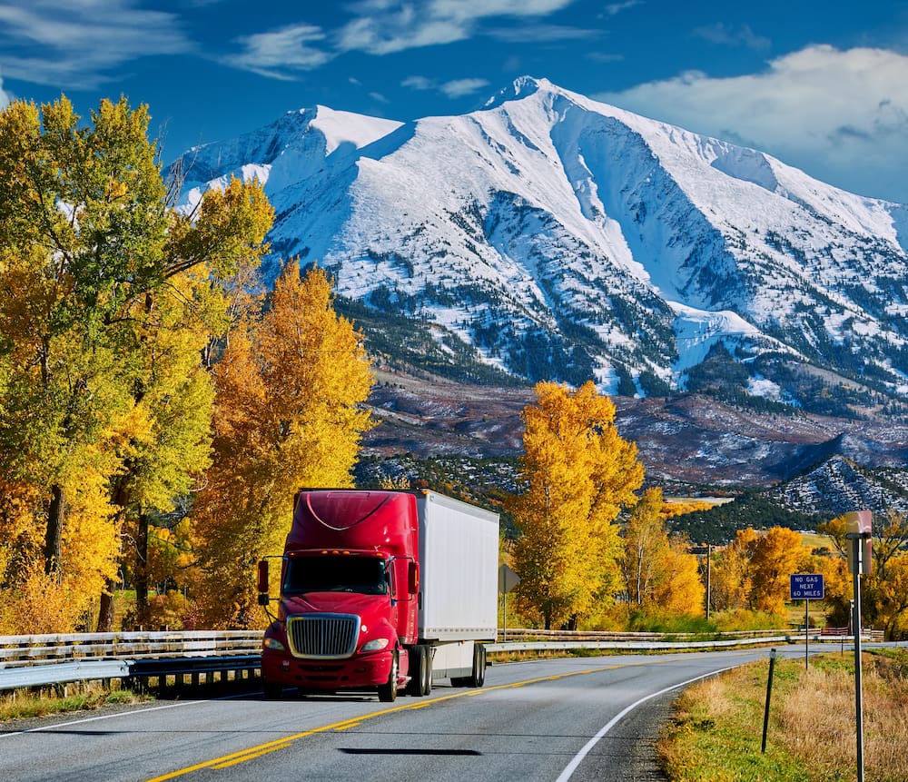 red and white truck on Colorado mountain road in the fall